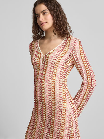 Frauenmodel trägt Slim Fit Maxikleid in Strick-Optik von Gina Tricot in Rosa, Gelb und Weiß mit V-Ausschnitt, Nahaufnahme Oberkörper.