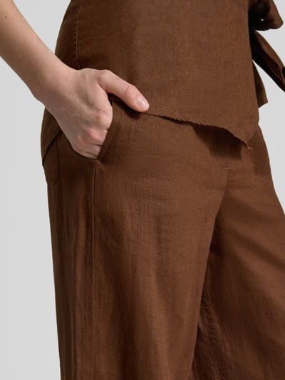 Vrouwenmodel draagt Loose Fit wijdte broek uit puur linnen van Tommy Hilfiger, all-over motief look, steekzakken, materiaal: linnen, detailopname heup