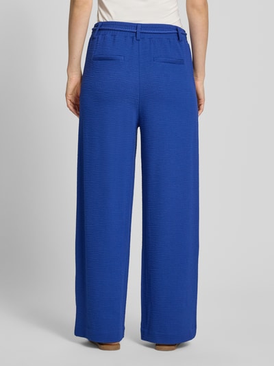 Frauenmodel trägt Wide Fit Stoffhose aus Viskose-Mix Modell 'Lumina' von ICHI in Blau mit Strukturmuster, Gesäßtaschen, Ganzkörperansicht Rückansicht.