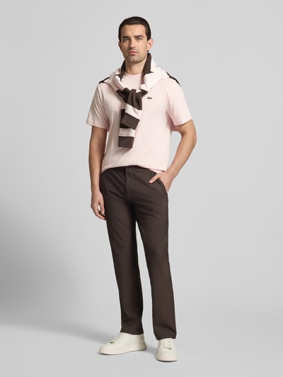 Mannenmodel draagt Regular Fit T-Shirt uit pure katoen van Lacoste in effen lichtroze met label stitching, logo-patch, ronde hals, korte mouw; volledige lichaamsaanzicht van voren.