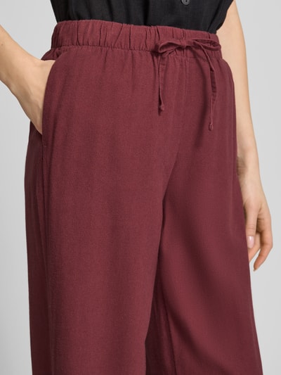 Kobieta nosi Wide Leg Leinenhose mit elastischem Bund Modell 'GOA' od Only, jednolity kolor, krój wide leg, materiał wiskozowo-lniany, kieszenie boczne, zbliżenie na górną część przodu.