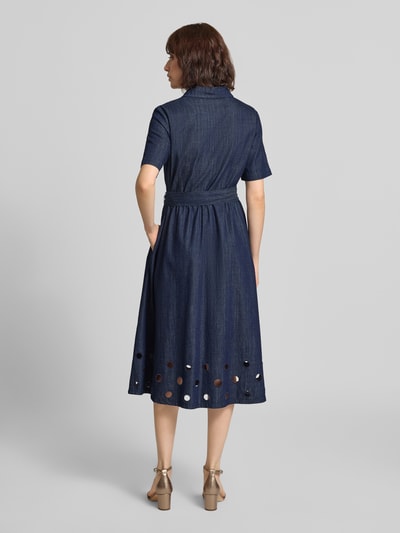 Frauenmodel trägt Hemdblusenkleid in Denim-Optik mit Bindegürtel von MORE & MORE, reine Baumwolle, A-Linie, Lochstickerei, Midikleid, Ganzkörperansicht Rückansicht.