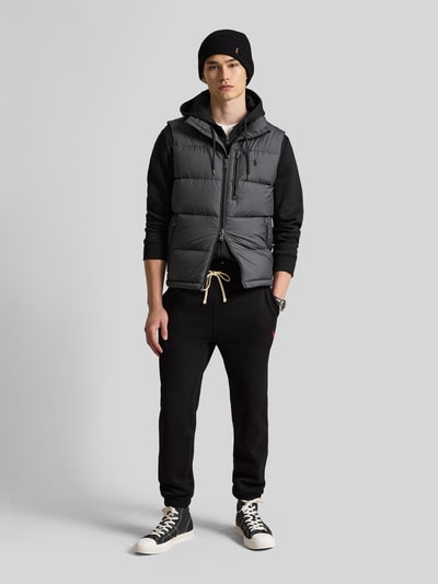 Männermodel trägt Regular Fit Weste mit Logo-Stitching von Polo Ralph Lauren in Dunkelgrau, strukturierte Oberfläche, Ganzkörperansicht von vorne. Herren Weste von Polo Ralph Lauren