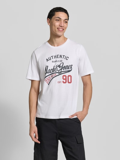 Männermodel trägt weißes T-Shirt mit Label-Print von Jack & Jones, Modell 'ETHAN', reine Baumwolle, gerader Schnitt, Nahaufnahme Oberkörper.
