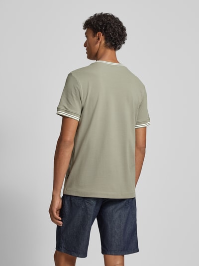 Männermodel trägt Herren T-Shirt mit Kontraststreifen Modell 'Jose' von JOOP! Collection aus grünem Baumwoll-Elasthan-Mix, Ganzkörperansicht Rückansicht.