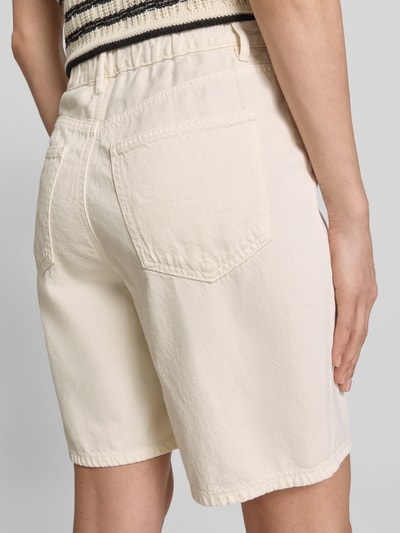 Vrouwenmodel draagt Regular Fit Bermudas uit katoen-lyocell-mix model 'VILLA' van Vero Moda in denimlook met 5-pocketmodel, mix van katoen en lyocell, kleur licht beige, boord met tunnelkoord en knoop- en ritssluiting, detailopname rugaanzicht.