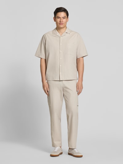 Männermodel trägt Relaxed Fit Cargohose mit Gürtelschlaufen Modell 'SRACKY' von BOSS Orange, unifarben, Ganzkörperansicht von vorne.