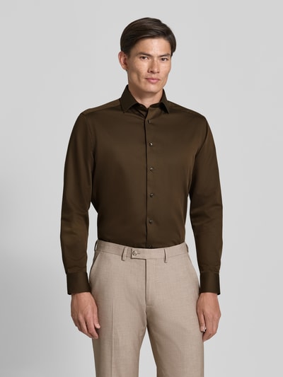 Męski model nosi Modern Fit Businesshemd aus reiner Baumwolle von OLYMP, brązowa koszula, beżowe spodnie, koszule biznesowe, Ganzkörperansicht von vorne