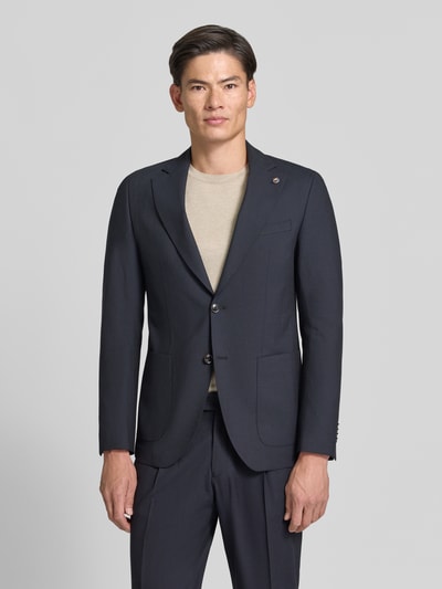 Männermodel trägt dunkelblaues Slim Fit 2-Knopf-Sakko aus Schurwoll-Mix von CG – CLUB of GENTS mit Reverskragen und aufgesetzten Taschen, Ganzkörperansicht von vorne. Modell Carver, Schurwoll-Mix mit Viskose-Anteil.