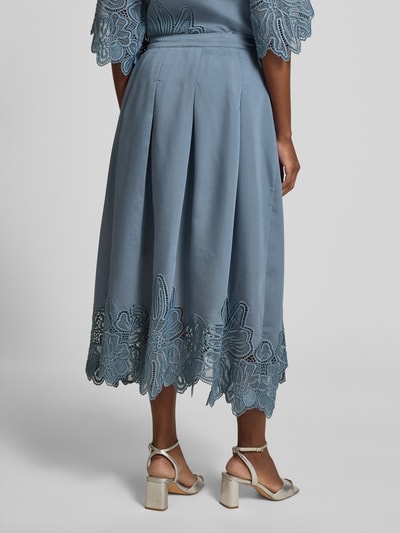 Frauenmodel trägt Midirock aus Lyocell-Mix Modell 'Molly' von Copenhagen Muse in Hellblau mit floralen Loch-Stickereien, Kellerfalten, A-Linie, Bundweite 37 cm, Gesamtlänge 87 cm, Ganzkörperansicht Rückansicht.