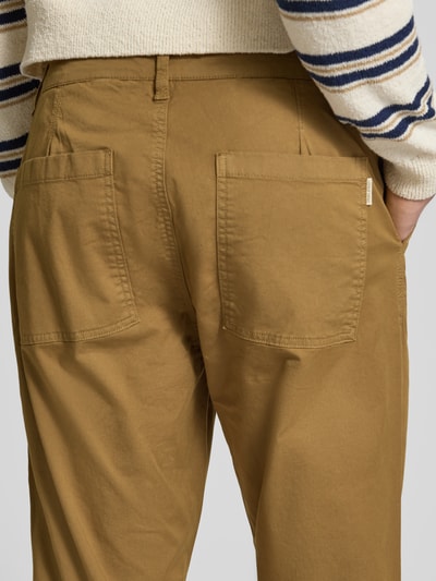 Männermodel trägt Chino mit Eingrifftaschen Modell 'MADDOX' von Blend, bawełna z domieszką elastanu, krój regular fit, kolor jasnobrązowy, szerokość w rozmiarze 32/32: 17 cm, długość nogawki wewnętrznej: 29 cm, ujęcie detailaufnahme tylu.