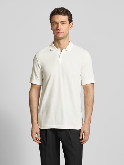 Männermodel trägt Regular Fit Poloshirt aus reiner Baumwolle von Marc O'Polo, unifarben, Gitterkaro Struktur, Ganzkörperansicht von vorne.