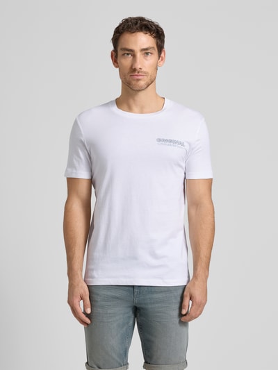 Männermodel trägt Regular Fit T-Shirt aus reiner Baumwolle von Tom Tailor Denim, weiß, unifarben, Rundhals, kurzarm, Label-Schriftzug, Ganzkörperansicht von vorne.