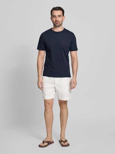 Männermodel trägt T-Shirt mit Label-Stitching und Rundhalsausschnitt von Scotch & Soda in Dunkelblau, Reine Baumwolle, Regular-Fit, Rückenlänge bei Größe M 68 cm, Ganzkörperansicht von vorne.