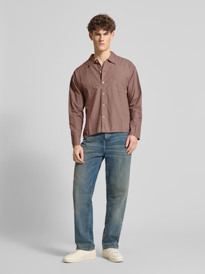 Męski model nosi Regular Fit Freizeithemd mit Kentkragen od Jack & Jones z bawełny ekologicznej, model 'AUSTIN', brustasza, listwa guzikowa, długość tyłu w rozmiarze M: 67 cm, szerokość ramion w rozmiarze M: 56 cm, długość rękawów w rozmiarze M: 60 cm, cała sylwetka z przodu.