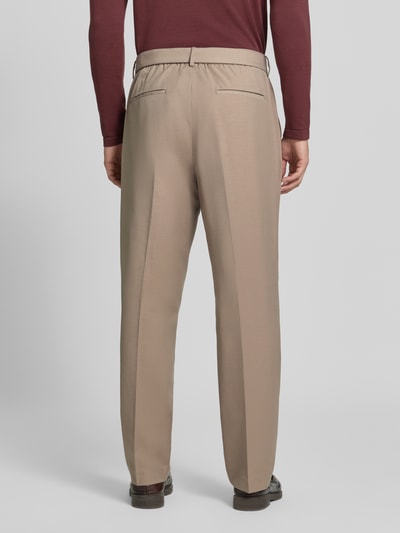 Männermodel trägt Hose mit Gürtel und Gesäßleistentaschen von Antony Morato in Beige mit Bügelfalte, Relaxed Fit, Ganzkörperansicht Rückansicht.
