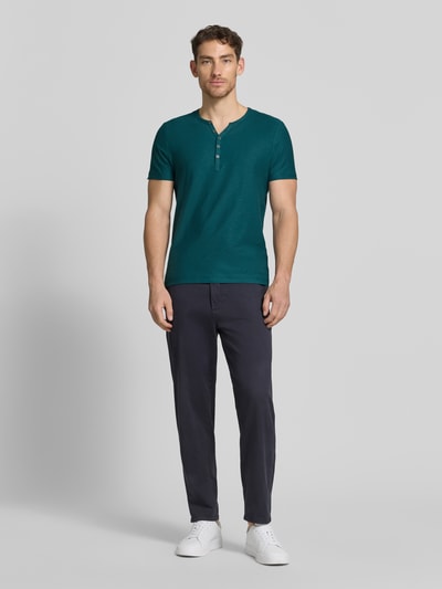 Mannenmodel draagt T-shirt met V-hals en knoopsluiting van MCNEAL in groen, puur katoen, regular fit, ruglengte maat M 68 cm, volledige vooraanzicht.