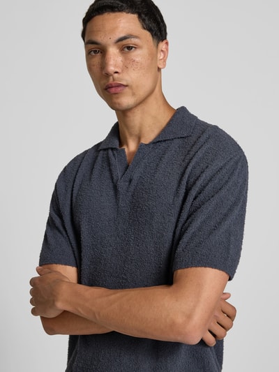 Männermodel trägt Regular Fit Poloshirt in Strick-Optik von Closed, Baumwoll-Mix, Polokragen, dunkelgraue Farbe, Nahaufnahme Oberkörper.