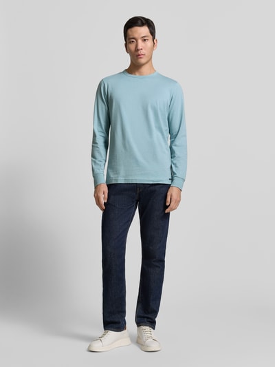 Männermodel trägt Regular Fit Langarmshirt aus reiner Baumwolle von Tom Tailor, unifarben, Jersey, Rundhals, Label Patch, Ganzkörperansicht von vorne