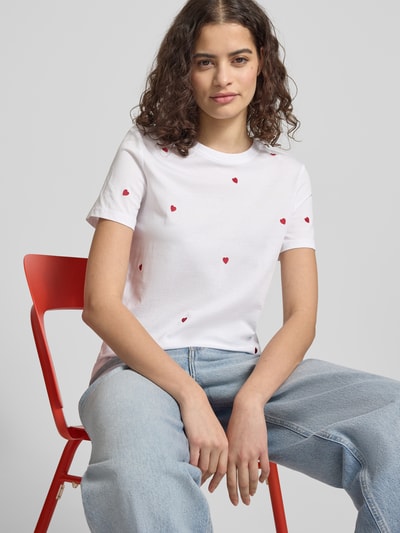 Frauenmodel trägt Regular Fit T-Shirt aus reiner Bio-Baumwolle Modell 'KETTY LIFE' von Only, unifarben mit Stickereien, Nahaufnahme Oberkörper.