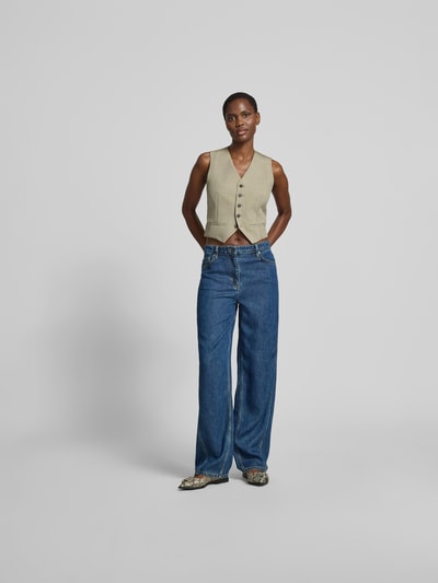 Frauenmodel trägt Straight Fit Jeans aus reinem Lyocell von Iro, 5-Pocket-Design, Ziernaht, Knopf- und Reißverschluss, Ganzkörperansicht von vorne.