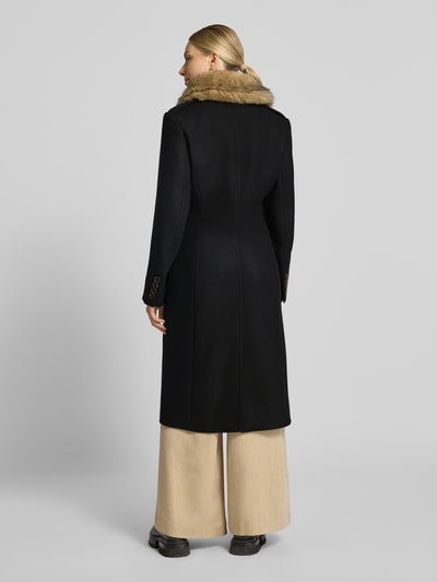 Frauenmodel trägt Mantel aus Schurwoll-Mix mit Kunstfell Modell 'BRADWALL' von DRYKORN in Schwarz, Struktur glatt, Ganzkörperansicht Rückansicht. Kontext: Slim Fit, Zweireiher, Knopfverschluss, Eingrifftaschen, Maße Größe 36.