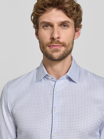 Männermodel trägt Super Slim Fit Businesshemd aus reiner Baumwolle von Jake*s, feines Karo-Muster in hellblau und weiß, Nahaufnahme Oberkörper.