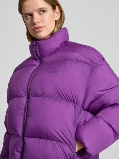 Vrouwenmodel draagt Steppjacke mit Label-Print - PUMA X P&C* van PUMA, paars, recht model, opstaande kraag, ritssluiting, steekzakken, unikleuren, bovenlichaam close-up.