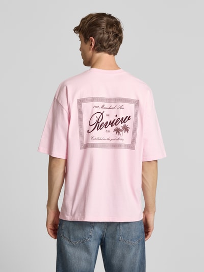Männermodel trägt T-Shirt mit Rundhalsausschnitt und Label-Print von REVIEW in Rosa, Reine Baumwolle, Relaxed-Fit, Rückenlänge 71 cm, Ganzkörperansicht Rückansicht.