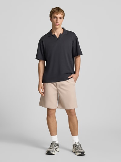 Männermodel trägt Loose Fit Shorts mit elastischem Bund Modell 'WILL' von Only & Sons, unifarben, Bundfalte, Eingrifftaschen, Ganzkörperansicht von vorne.