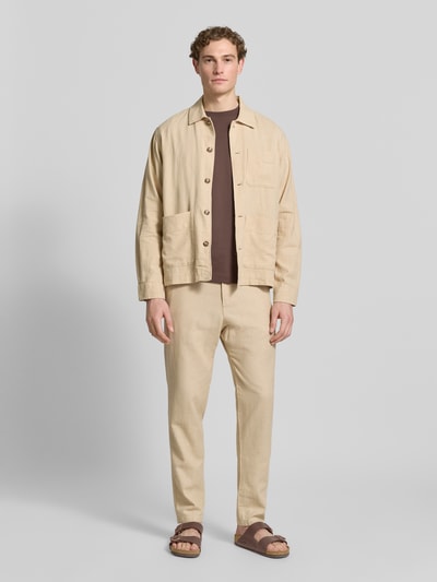 Männermodel trägt Regular Fit Hose aus Baumwoll-Leinen-Mix Modell 'BRODY' von SELECTED HOMME in Unifarben mit Melange-Optik, Ganzkörperansicht von vorne.