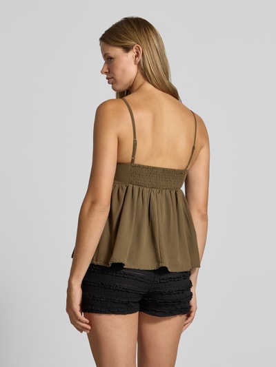 Frauenmodel trägt Regular Fit Blusentop mit Perlenstickerei Modell 'JAVUN' von ONLY, olivgrün, schwarze Shorts, Ganzkörperansicht Rückansicht, Damen Blusentop von ONLY