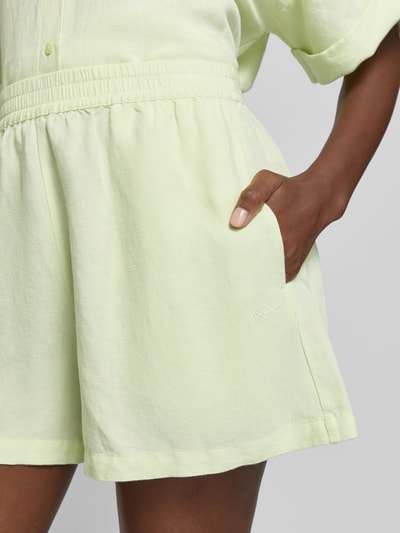Frauenmodel trägt Relaxed Fit Shorts aus Leinen-Viskose-Mix Modell 'TALLAN' von BOSS Orange, unifarben, elastischer Bund, Nahaufnahme Oberschenkel.