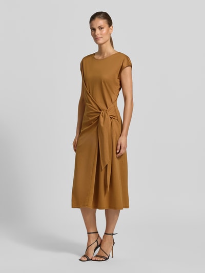 Frauenmodel trägt Midikleid in Wickel-Optik von Rinascimento in Braun, taillierte Passform, Rundhalsausschnitt, Ganzkörperansicht von vorne. Baumwoll-Modal-Mix, kurzärmelig, glatte Textur, knieumspielende Länge.