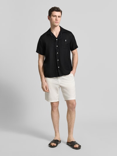 Männermodel trägt Regular Fit Freizeithemd aus reinem Leinen von Polo Ralph Lauren in Schwarz, Kurzarm, Reverskragen, Flammgarn, Ganzkörperansicht von vorne