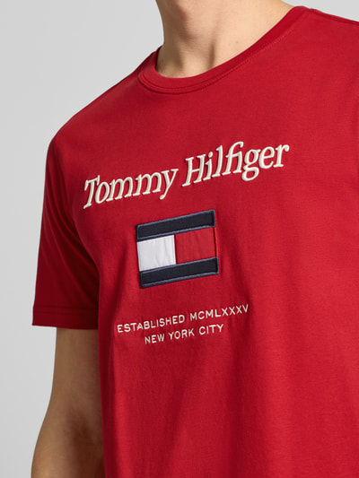 Männermodel trägt Regular Fit T-Shirt aus reiner Baumwolle von Tommy Hilfiger in Optik: Unifarben, Label-Schriftzug, Nahaufnahme Oberkörper.
