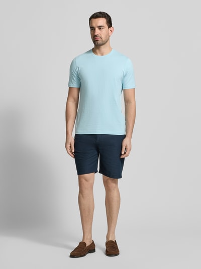 Męski model nosi T-Shirt mit Label-Detail od bugatti w kolorze jasnoniebieskim, z czystej bawełny, krój regular fit, okrągły dekolt, długość pleców w rozmiarze M: 69 cm, widok całej sylwetki z przodu.