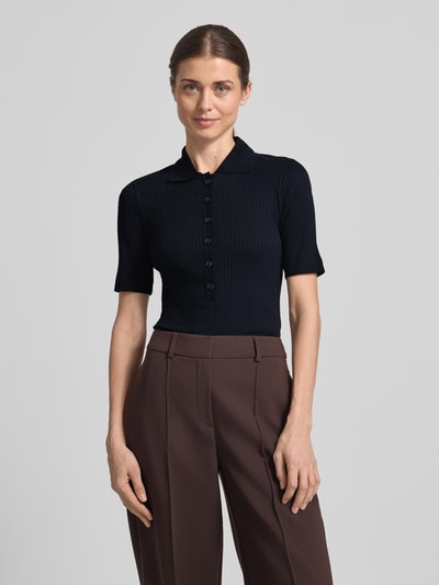 Vrouwenmodel draagt Slim Fit Poloshirt uit katoen-modal-mix van Marc O'Polo, effen kleuren, korte mouw, ribtricot, knoopsluiting. Ganzkörperansicht van voren.