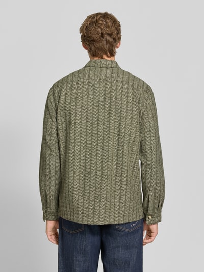 Männermodel trägt Relaxed Fit Hemdjacke mit Kentkragen und Brusttaschen von Scotch & Soda, Mieszanka materiałów z dodatkiem wełny, wzór na całej powierzchni, detal z logo, długość tyłu w rozmiarze M: 74 cm, Ganzkörperansicht Rückansicht