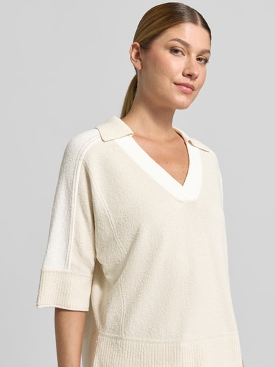 Frauenmodel trägt Regular Fit Bluse in Strick-Optik von Marc Cain in creme, Baumwoll-Mix, V-Ausschnitt, Halbarm, Nahaufnahme Oberkörper.