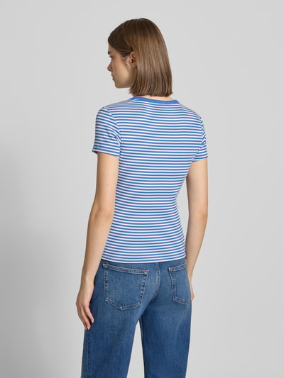 Frauenmodel trägt Slim Fit T-Shirts aus Baumwoll-Mix im 2-er-Pack von Tommy Jeans, mehrfarbig gestreift, Ganzkörperansicht Rückansicht.