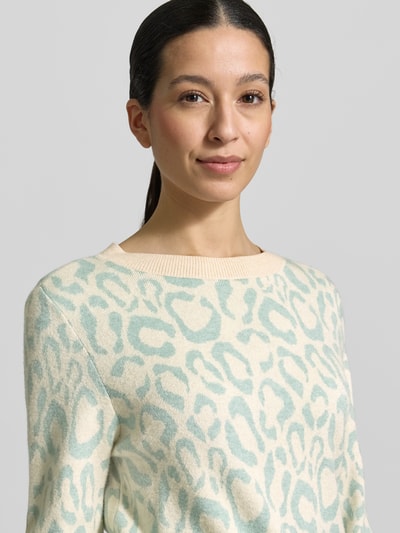 Frauenmodel trägt Slim Fit Pullover aus Viskose-Mix Modell 'JACQUARD' von Vila mit Strick-Optik, Allover-Animal-Stitching, Rundhalsausschnitt, elastischen Abschlüssen; sanfte Farben, Nahaufnahme Oberkörper.