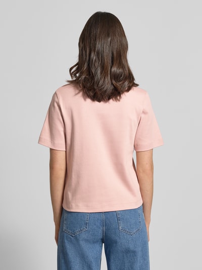 Kobiece modelka nosi T-shirt mit Rundhalsausschnitt und Label-Stitching od Oui z bawełny, krój regular fit, długość tyłu w rozmiarze 36: 56 cm, widok całej sylwetki z tyłu.