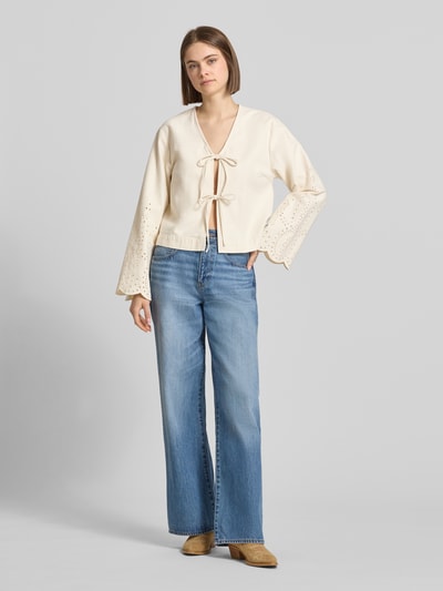 Kobiece model nosi Regular Fit Jeansbluse aus reiner Baumwolle Modell 'ELSA' von Only, tkanina stylizowana na denim, krój regular fit, zapięcie na pętelkę, rozszerzane rękawy, zakończenie rękawów: haft angielski, materiał: bawełna, jasne kolory, gładka tekstura, Ganzkörperansicht von vorne.