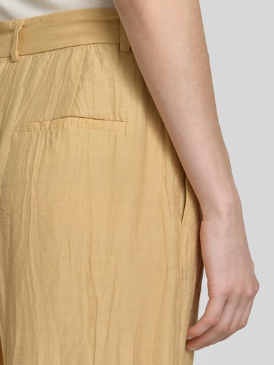 Frauenmodel trägt Hose aus Viskose-Mix in Crinkle-Optik von Jake*s Collection, beige, Gesäßtasche, Struktur, Nahaufnahme Oberkörper.
