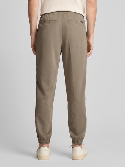 Männermodel trägt Regular Fit Stoffhose aus Viskose-Mix mit elastischem Bund von ARMANI EXCHANGE, Ziernähte, Gesäßtaschen, Beinabschlüsse, Ganzkörperansicht Rückansicht.