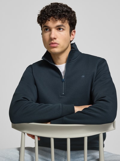 Männermodel trägt Sweatshirt mit Stehkragen und Reißverschluss von G-Star Raw aus Baumwoll-Mix, Regular-Fit, Label-Stitching, Nahaufnahme Oberkörper.