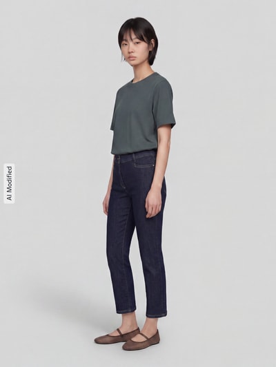Frauenmodel trägt Slim Fit Jeans aus Baumwoll-Mix Modell 'Jenny Smart' von TONI, dunkle Farbe, schmale Form, Damen Slim Fit Jeans von TONI, Ganzkörperansicht von vorne, KI-modifiziertes Bild.