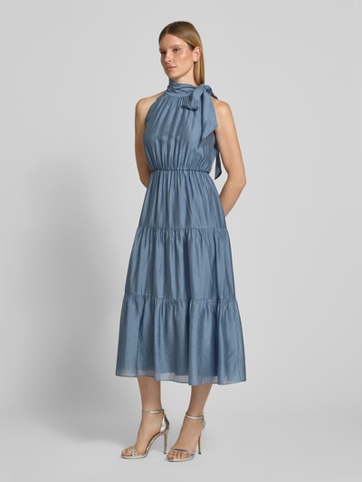 Frauenmodel trägt Cocktailkleid aus Viskose-Mix im Stufen-Look von Christian Berg Cocktail in Blau mit Stehkragen und Schleifen-Applikation, A-Linie, Midikleid, glatte Textur, Ganzkörperansicht von vorne, Rückenlänge bei Größe 36: 129 cm, Brustweite bei Größe 36: 46 cm.