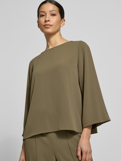 Vrouwenmodel draagt Relaxed Fit blouse met ronde hals van comma, elastische materiaalmix, met lange mouwen, ruglengte 57 cm, mouwlengte 51 cm, olijfgroen, effen, zachte textuur, nahaufnahme bovenlichaam.